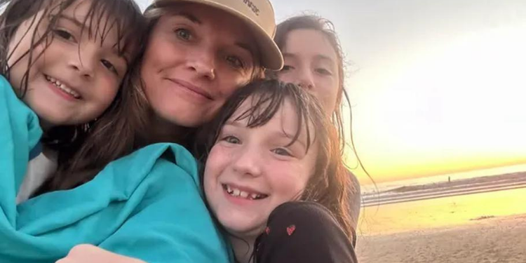 Jamie Lenio poses with her three children on a beach in a photo posted to her GoFundMe page